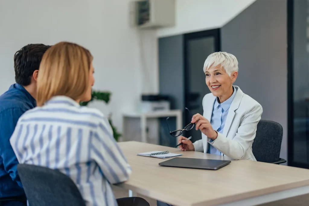 Échange entre une conseillère SOLVIA et des clients lors d’un rendez-vous de projet d’habitat modulaire, écoute et compréhension des besoins, accompagnement personnalisé en France