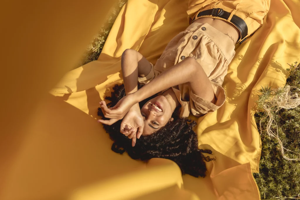 Femme allongée en extérieur dans une ambiance naturelle et chaleureuse, illustrant l’univers éditorial et inspirant du blog SOLVIA autour de l’habitat modulaire en France